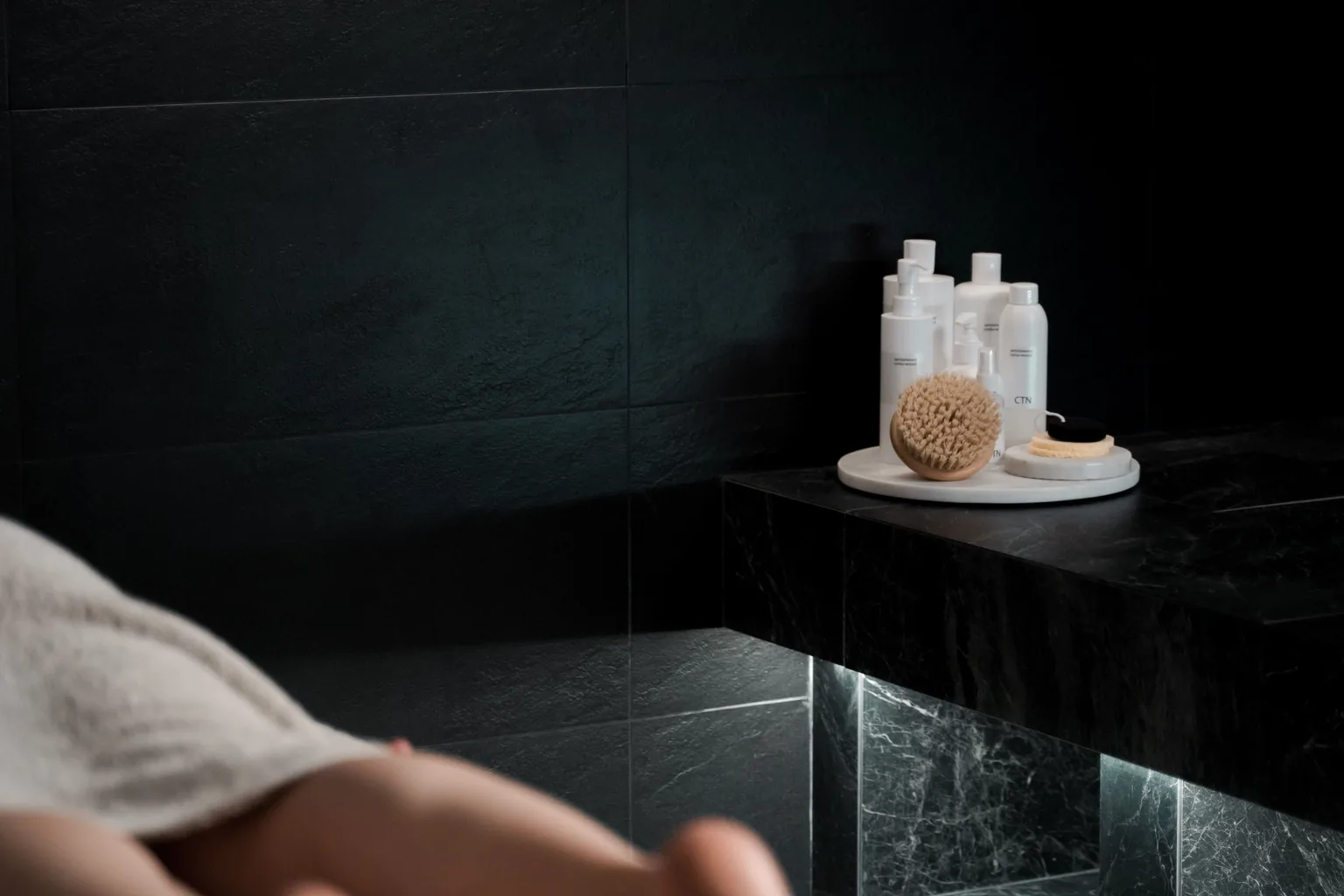 Détail d’un espace spa sombre avec accessoires de soin